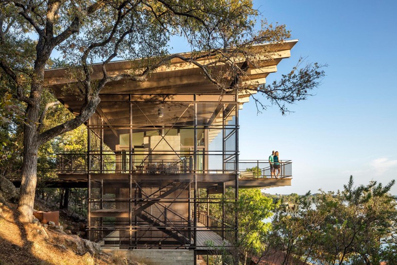 lake flato constructs vertical lakeside retreat above the tree line in texas