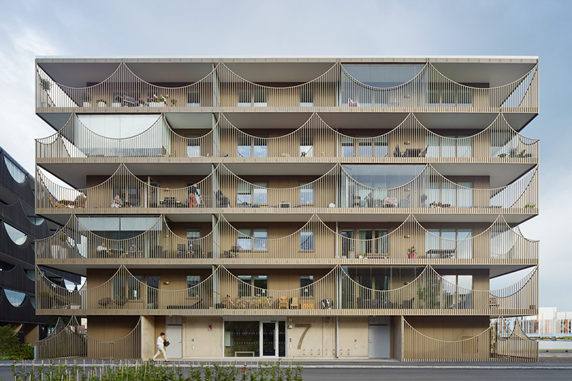 tham & videgård arkitekter's housing scheme in sweden has inverted arch balconies