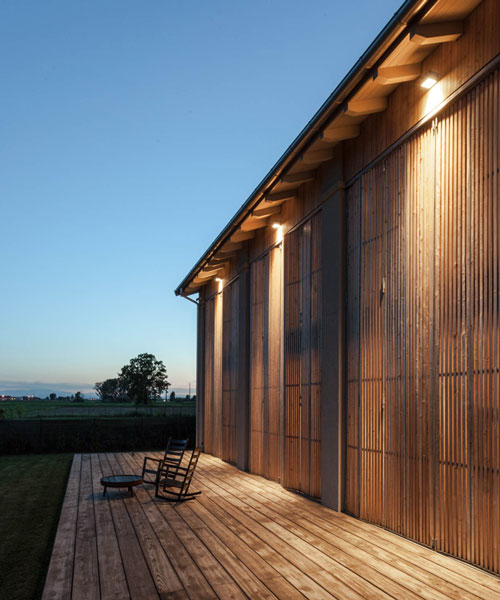 archiplan adds a façade of folding shutters to italian barnhouse renovation