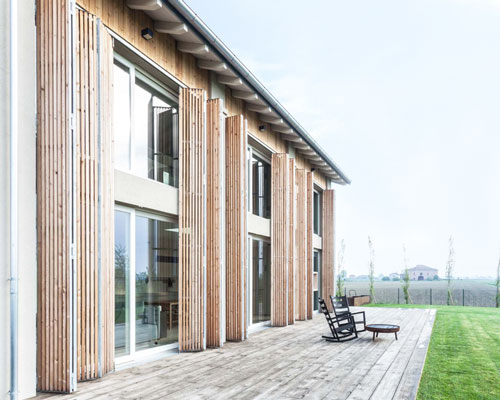 archiplan adds a façade of folding shutters to italian barnhouse renovation