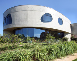 curving concrete house in brazil by ruy ohtake hosts a collection of design objects