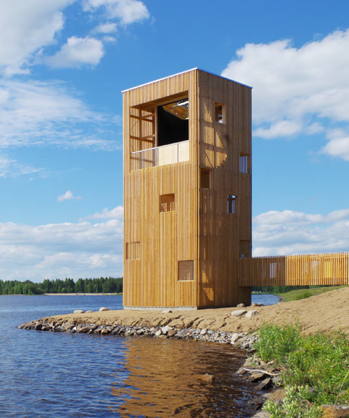 OOPEAA's wooden observation tower sits by man-made lake in finland