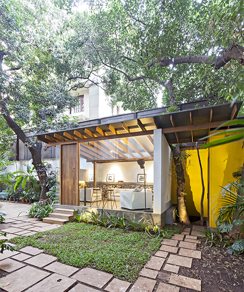 abraham john architects have constructed a pavilion under a tropical scene in mumbai