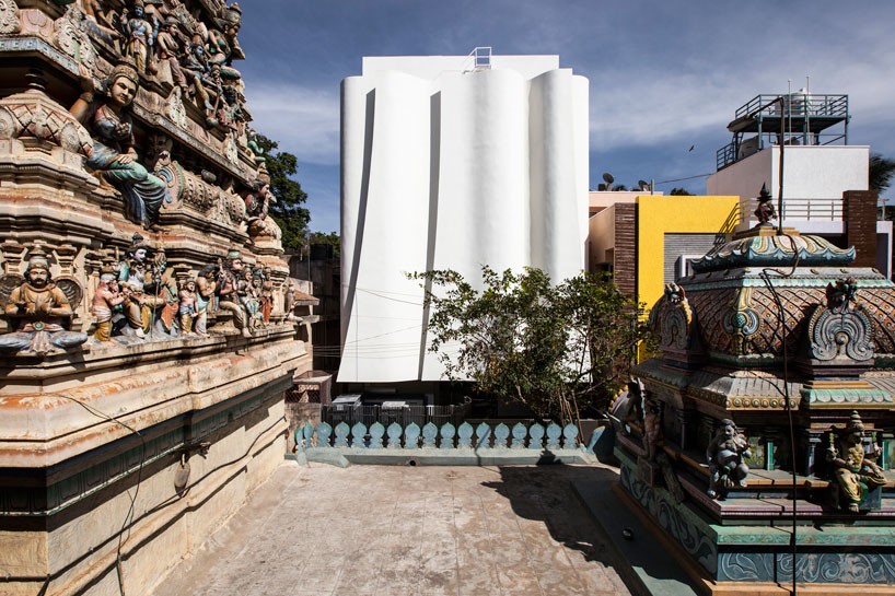 cadence's health clinic with folding façade sits adjacent to an ancient indian temple