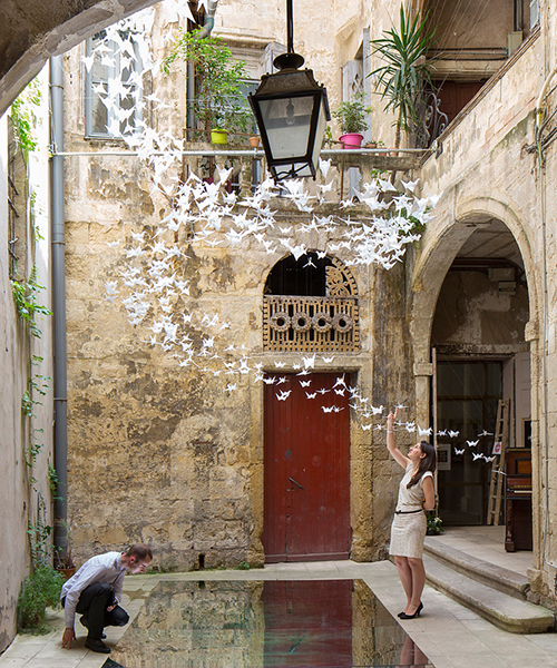 flock of origami birds fills french courtyard for the festival des architectures vives