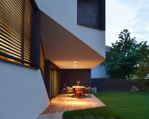 elastik + hikikomori's mezzanine house in ljubljana uses a cantilever to shelter exterior terrace