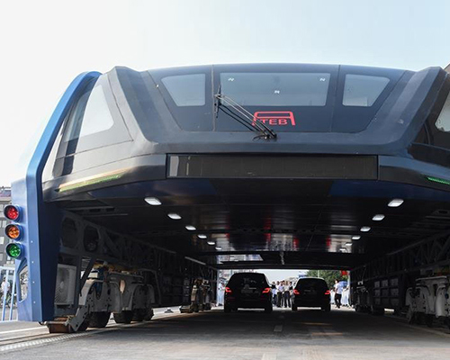 giant elevated bus straddles and soars over cars in first test drive in china