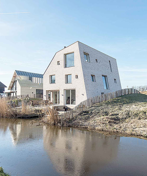 global architects' asymmetric rock house emerges from dune landscape in holland