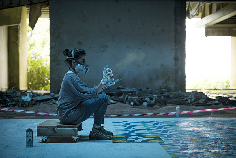 javier de riba spray paints tile floor in an abandoned hotel