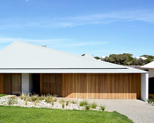vibe design group covers house in melbourne with asymmetric steel roof