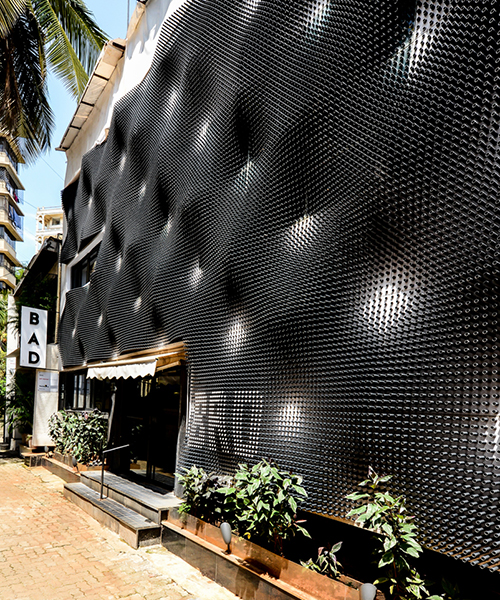 NUDES covers the bad café in mumbai with a rippling skin of plastic cylinders
