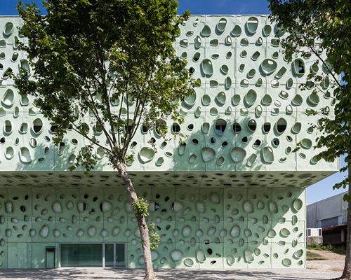 cláudio vilarinho punctures mint green university building with asymmetric openings