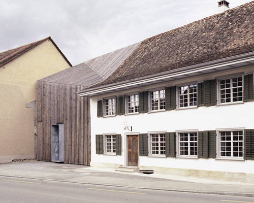 marazzi reinhardt slots farmhouse intervention between traditional swiss buildings