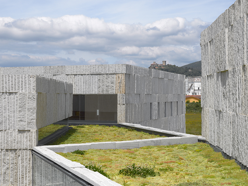 zooco estudio builds an arts and culture center in spain formed of six stone-clad volumes