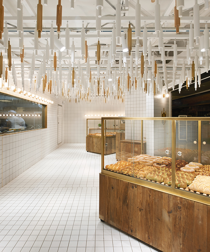 rolling pins hang from ceiling inside beijing bakery by B.L.U.E architecture studio