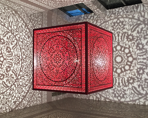 anila quayyum agha's luminous red cube casts intricate shadows