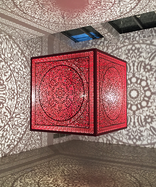 anila quayyum agha's luminous red cube casts intricate shadows