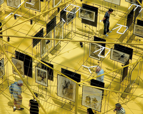 OTTOTTO's prismatic pavilion suspends terry o' neill photos in a maze of rebar