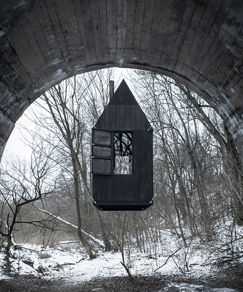 H3T architects' 'flying black house' looms beneath a bridge in the czech republic