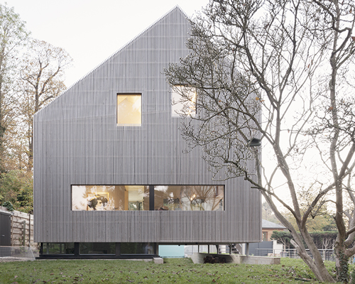 karawitz wraps asymmetric home entirely in grey larch wood in france