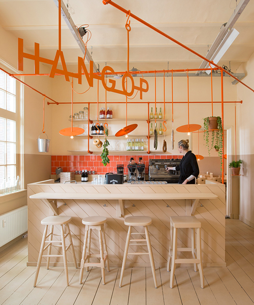 overtreders W hangs orange rail above hangop dutch café