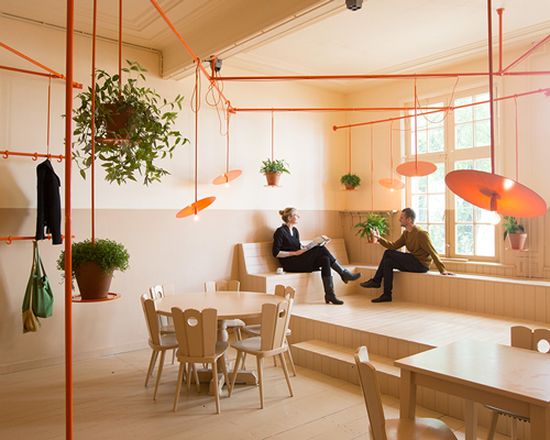 overtreders W hangs orange rail above hangop dutch café