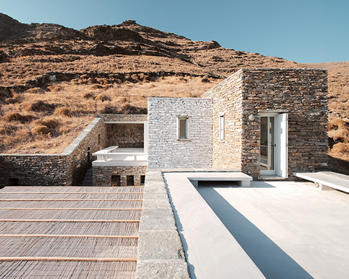 cometa architects builds rocksplit house into the greek island hillside