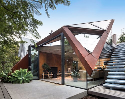 angular corten roof folds down over leaf house extension in melbourne