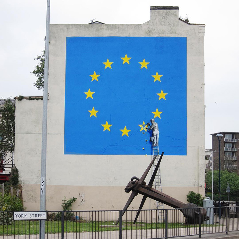 banksy takes on brexit: mural shows metalworker chipping away at the EU flag