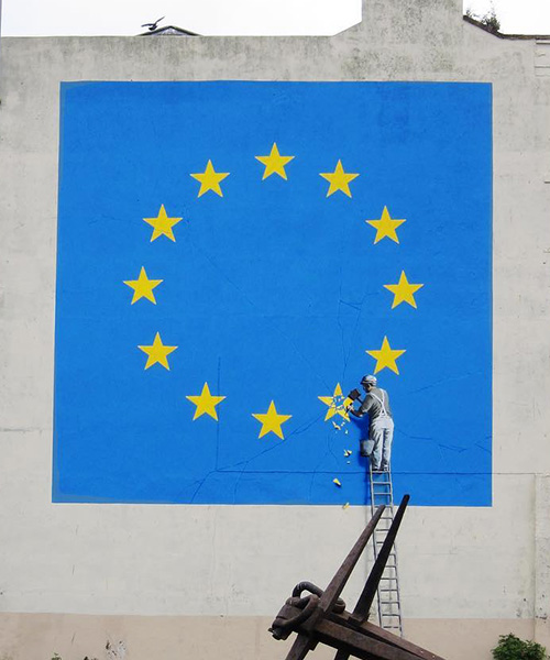 banksy takes on brexit: mural shows metalworker chipping away at the EU flag