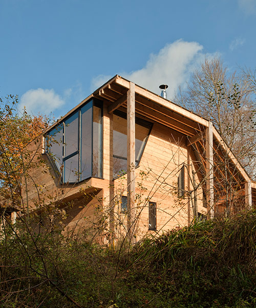 invisible studio designs caretaker's house with a variety of local timber
