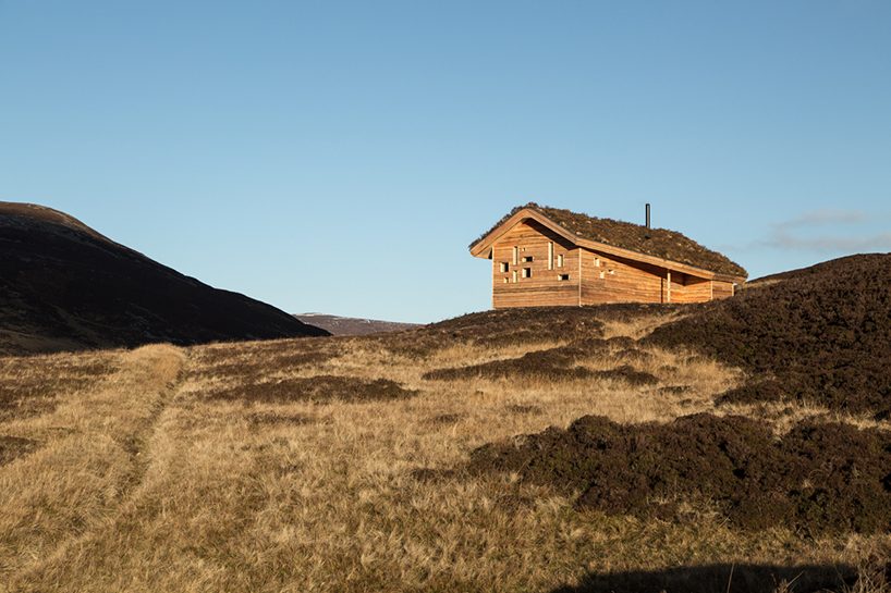 moxon architects' moss-topped mountain hut blends into the scottish highlands
