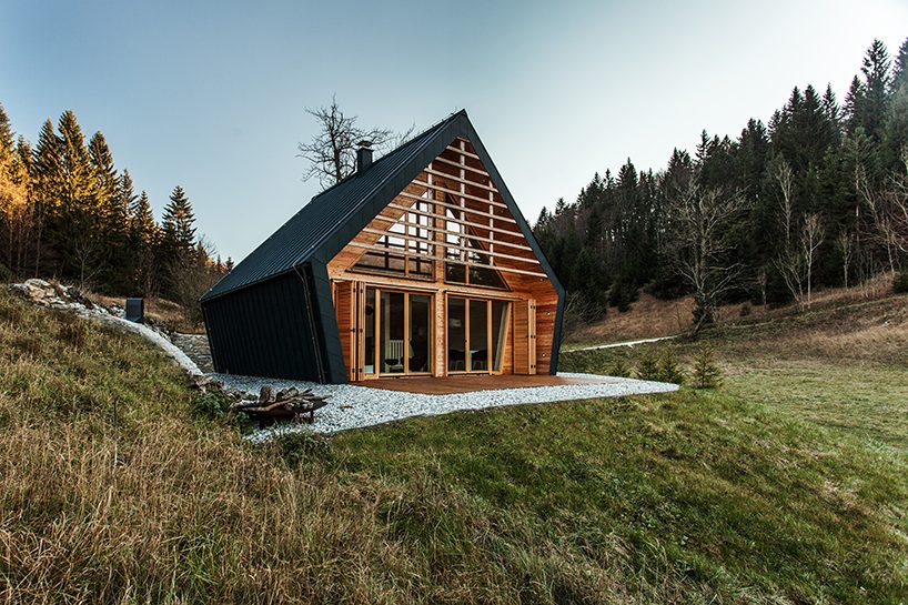 studio PIKAPLUS sets wooden house against backdrop of forests