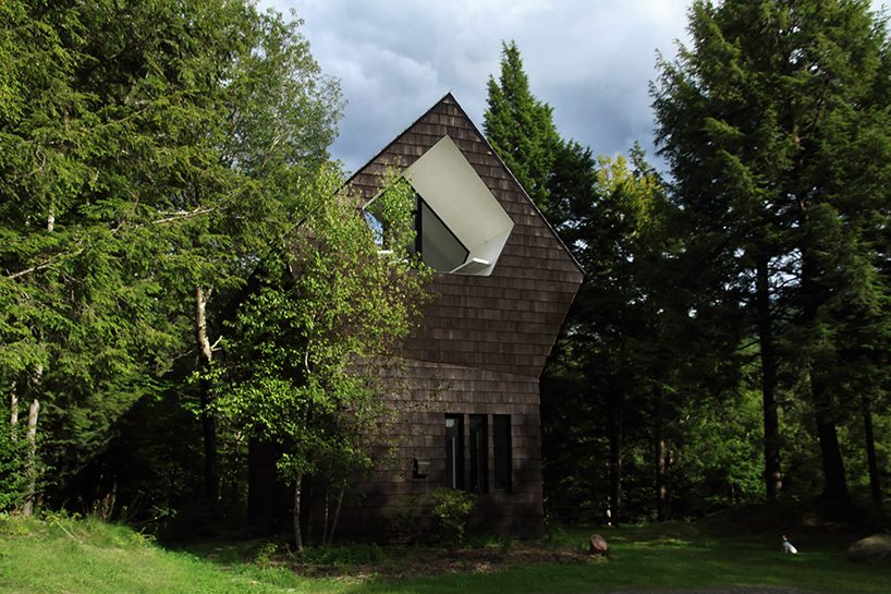 bird hut house by YH2 emerges from the trees in canadian forest