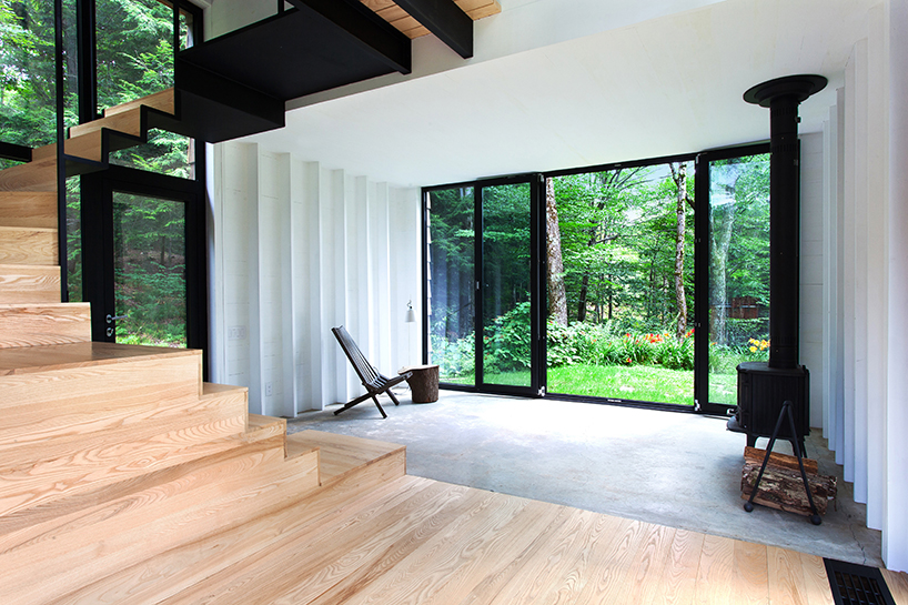 bird hut house by YH2 emerges from the trees in canadian forest