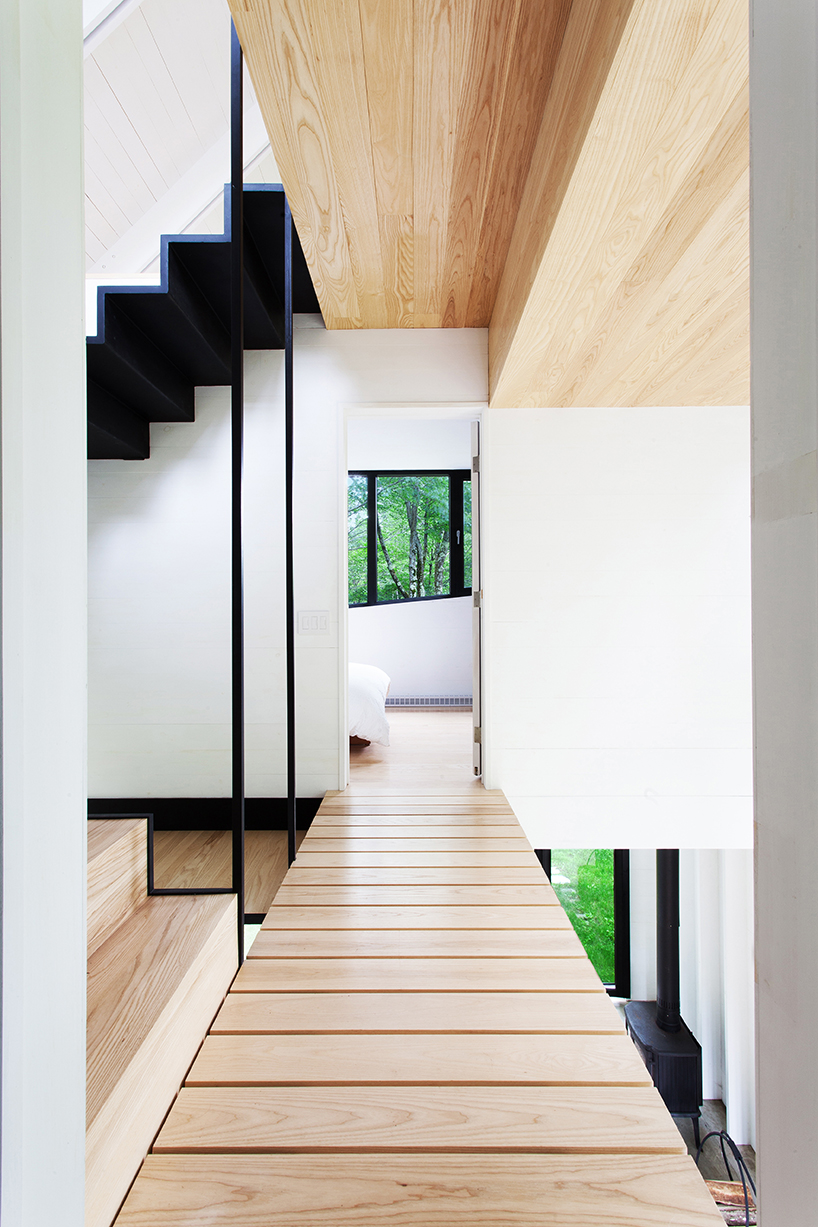 bird hut house by YH2 emerges from the trees in canadian forest