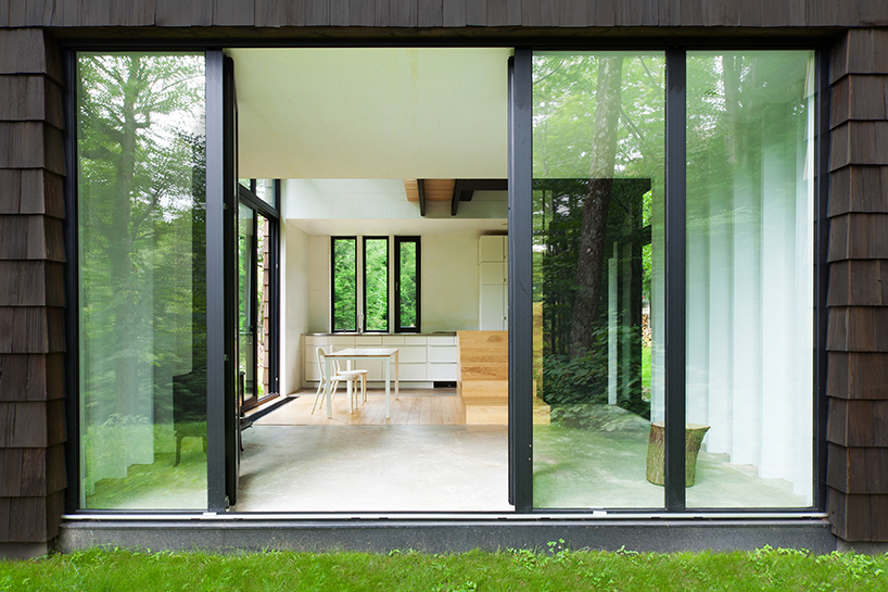 bird hut house by YH2 emerges from the trees in canadian forest