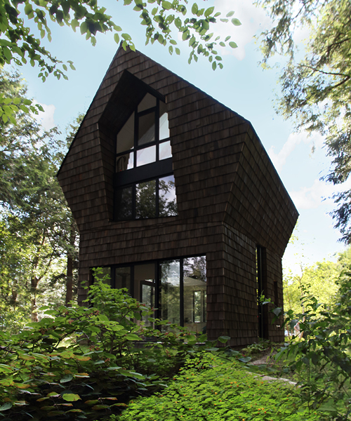 bird hut house by YH2 emerges from the trees in canadian forest