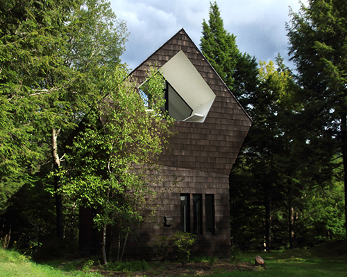 bird hut house by YH2 emerges from the trees in canadian forest