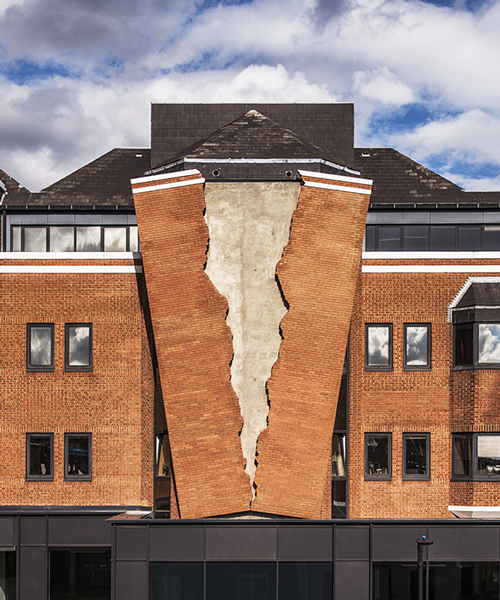 alex chinneck fractures the façade of a brick building in london