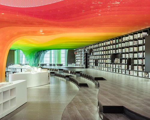 wutopia lab's metal rainbow bookstore welcomes visitors with a succession of colorful panels