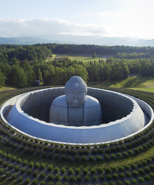 tadao ando surrounds giant buddha statue at a japanese cemetery with landscaped hill