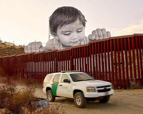 child curiously peeks over the US-mexico border in JR's installation on immigration