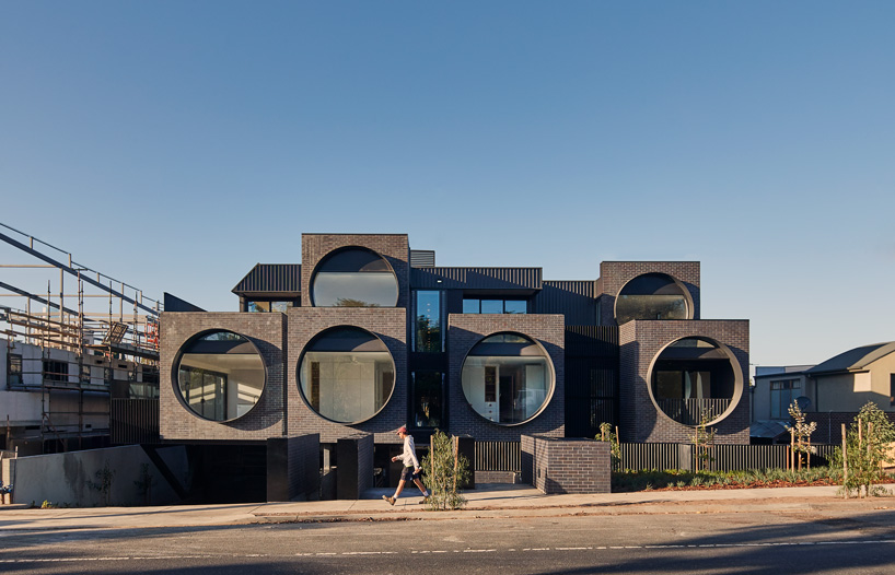 bkk architects frames cirqua apartments near melbourne with oversized, circular windows