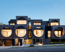 bkk architects frames cirqua apartments near melbourne with oversized, circular windows