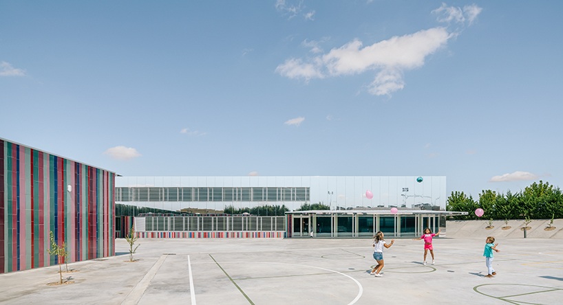 ABLM combines reflective mirrors with strips of vibrant colorful ceramic in school façade