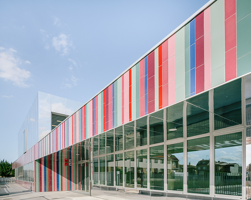 ABLM combines reflective mirrors with strips of vibrant colorful ceramic in school façade