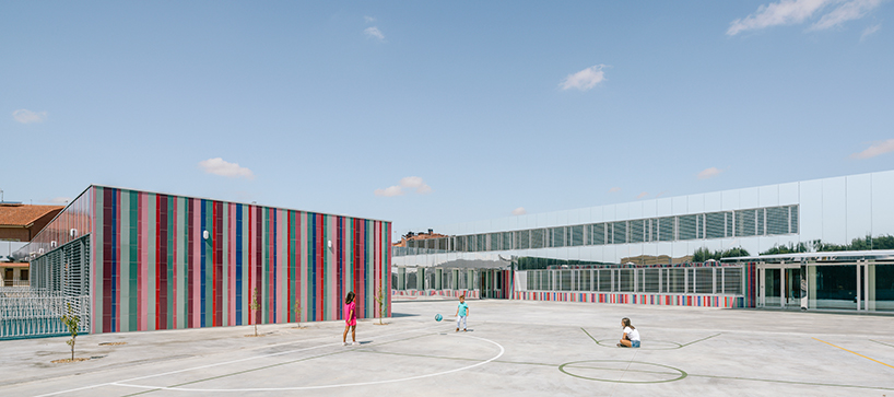 ABLM combines reflective mirrors with strips of vibrant colorful ceramic in school façade