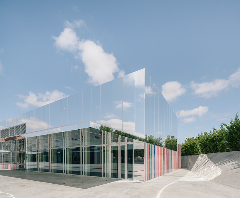 ABLM combines reflective mirrors with strips of vibrant colorful ceramic in school façade