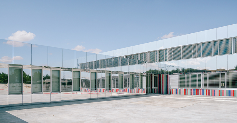 ABLM combines reflective mirrors with strips of vibrant colorful ceramic in school façade